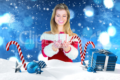 Composite image of pretty girl in santa outfit holding gift