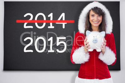 Composite image of smiling brunette in santa claus holding a pig