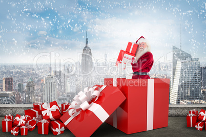 Composite image of santa standing in large gift