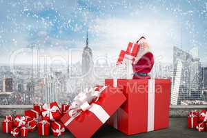 Composite image of santa standing in large gift