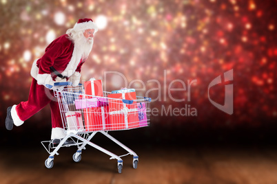 Composite image of santa pushes a shopping cart