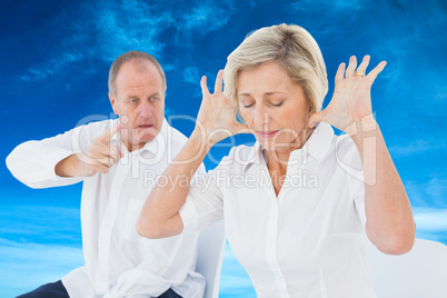 Composite image of older couple sitting in chairs arguing