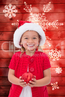 Composite image of cute little girl wearing santa hat holding ba