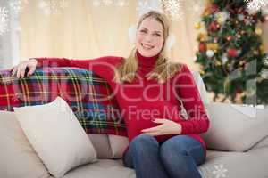 Composite image of beautiful pregnant woman sitting on a couch
