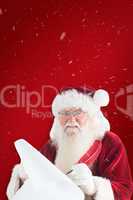 Composite image of santa claus writing on scroll