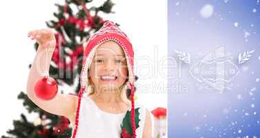 Composite image of festive little girl holding christmas bauble