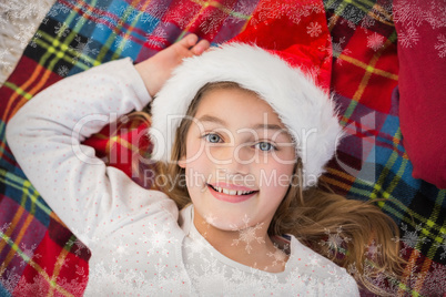 Composite image of festive little girl smiling on blanket