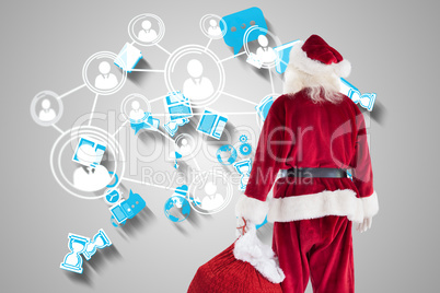 Composite image of santa carrying sack of gifts