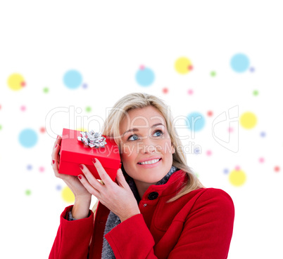 Composite image of festive blonde holding red gift