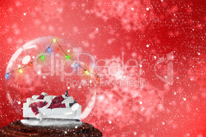 Composite image of santa sleeping in snow globe