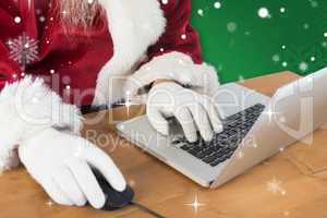 Composite image of santa surfs on the internet