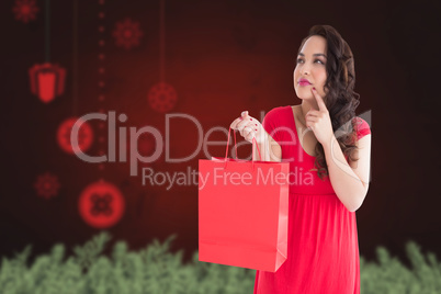 Composite image of thoughtful brunette holding shopping bag