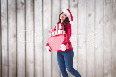 Composite image of happy brunette holding many gifts