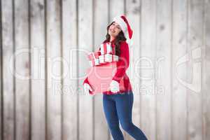 Composite image of happy brunette holding many gifts