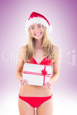 Festive fit blonde in red bikini showing gift