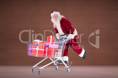 Composite image of santa pushing shopping cart