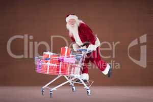 Composite image of santa pushing shopping cart