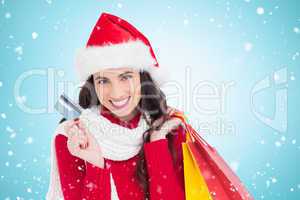 Composite image of excited brunette holding shopping bags and cr