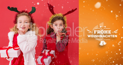 Composite image of festive little girls holding gifts
