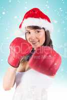 Composite image of festive brunette punching with boxing gloves