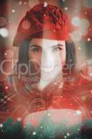 Composite image of smiling brunette with cover and red hat