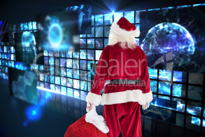 Composite image of santa carrying sack of gifts