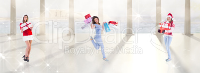 Composite image of festive brunette holding pile of gifts