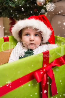 Composite image of cute baby boy in large christmas present