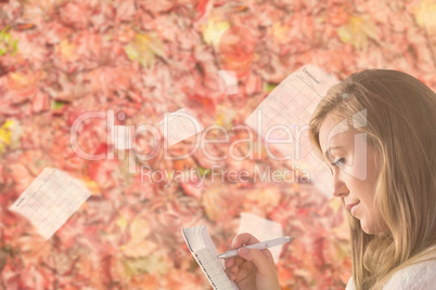 Pretty blonde relaxing on the couch writing in notepad