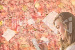 Pretty blonde relaxing on the couch writing in notepad