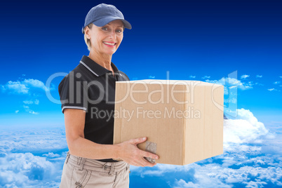 Composite image of happy delivery woman holding cardboard box