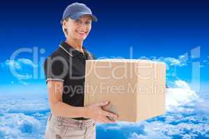 Composite image of happy delivery woman holding cardboard box