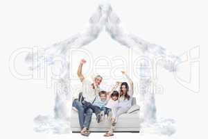 Composite image of family sitting on sofa raising their arms