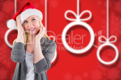 Composite image of festive blonde smiling in santa hat