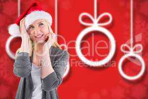 Composite image of festive blonde smiling in santa hat