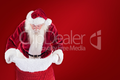 Composite image of santa looks in his bag