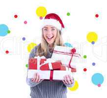 Composite image of festive blonde holding pile of gifts