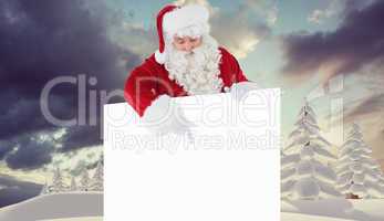 Composite image of cheerful santa claus presenting sign