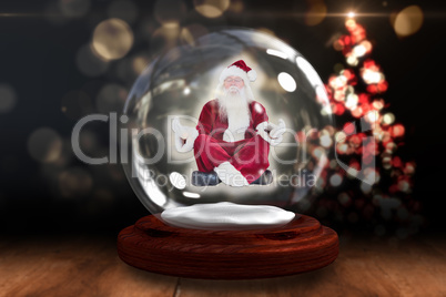 Santa doing yoga in snow globe