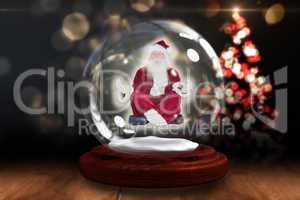 Santa doing yoga in snow globe