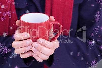 Composite image of close up of a woman in warm clothing holding