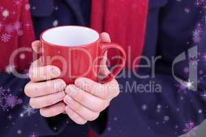 Composite image of close up of a woman in warm clothing holding