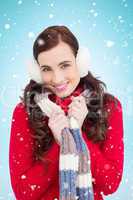 Composite image of happy brunette in winter clothes smiling at c