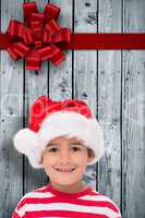 Composite image of cute little boy in santa hat