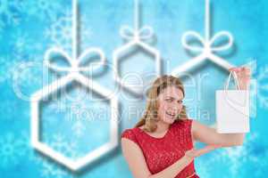 Composite image of smiling woman presenting a shopping bag