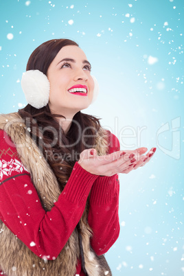 Composite image of brunette in winter clothes with hands out