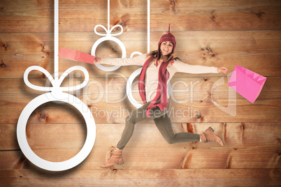 Composite image of happy brunette jumping with gifts bags