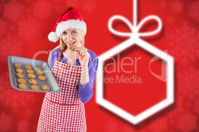 Composite image of festive blonde showing hot cookies