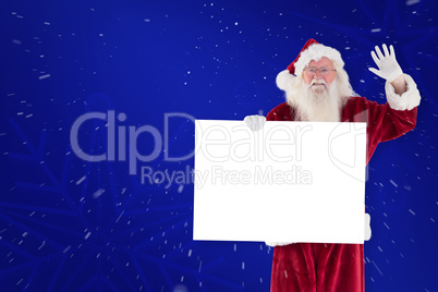 Composite image of santa holds a sign and is waving