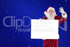 Composite image of santa holds a sign and is waving